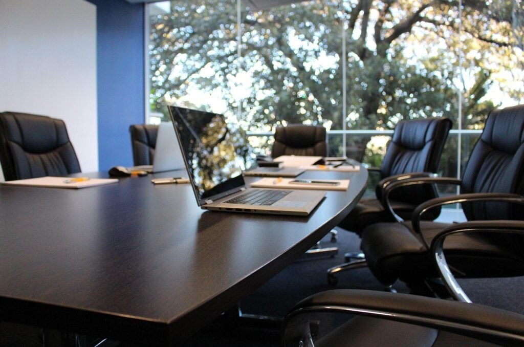 A row of empty office desks with laptops, representing junior technical hiring falling at Anthropic as AI agents log six times the hours of staff, October 2026
