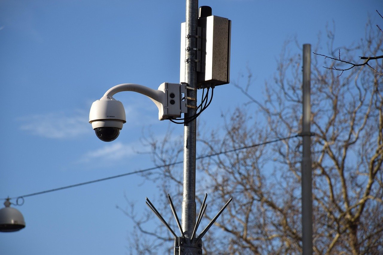 A surveillance camera mounted on a pole above a street, representing the licence-plate reader network that ran thousands of immigration lookups.